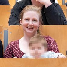 Studentin mit Kind im Hörsaal