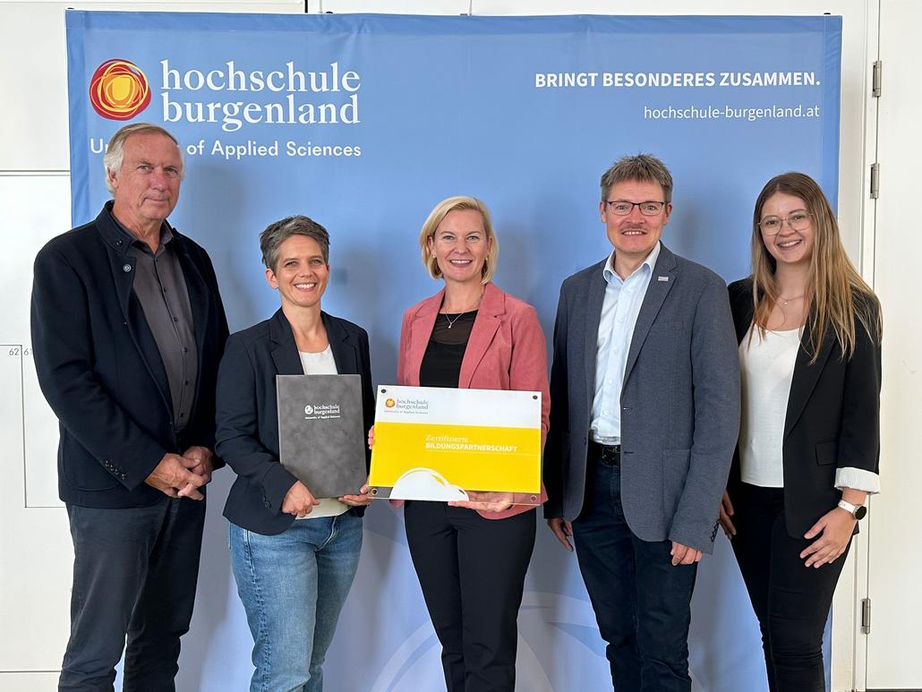 Fünf Personen vor der Hochschule Burgenland mit Urkunde und Mappe