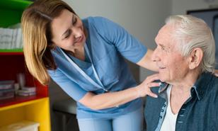 Ein alter Mann mit einer Physiotherapeutin