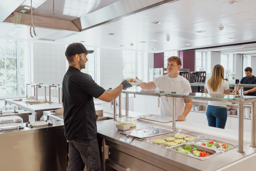 Ein Student holt sich Essen in der Mensa